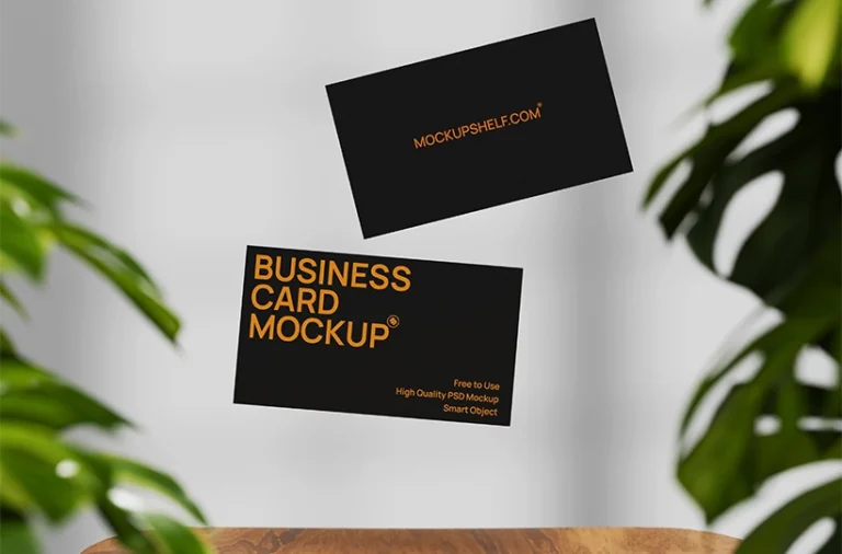 Free black floating business card mockup PSD with suspended cards, leaf framing, and wooden table