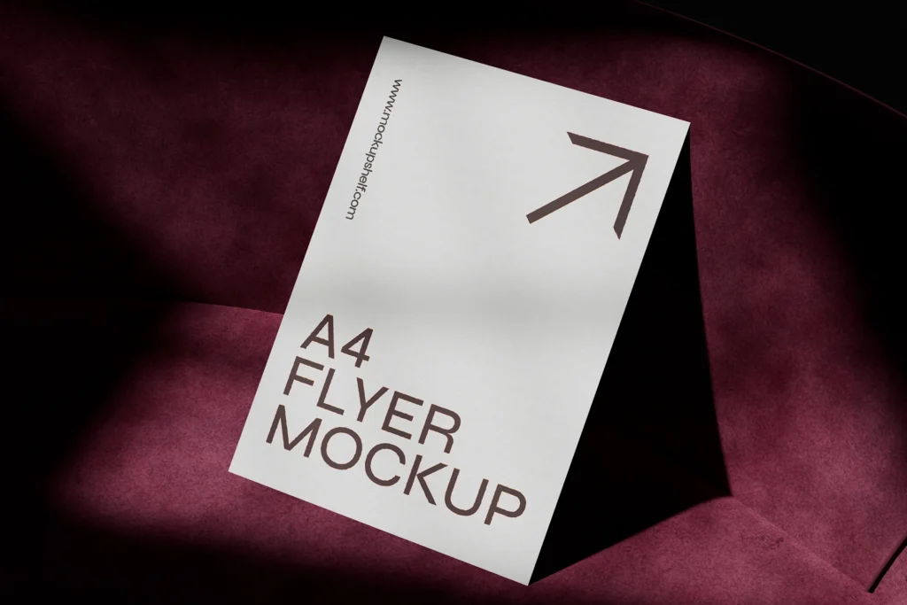 A4 flyer mockup on a burgundy velvet sofa with dramatic shadows